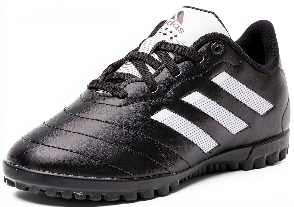Child wearing Adidas junior turf soccer shoes on a green artificial field